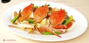 VIDEO // Un crab gătit de viu mănâncă în tigaie ingredientele de lângă el