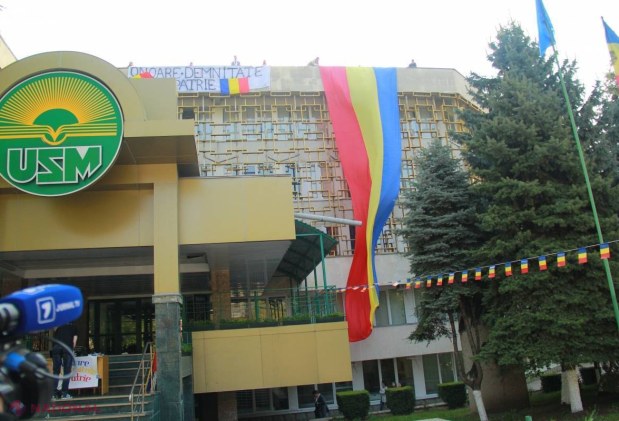 Reportaj FOTO // Un tricolor URIAȘ a fost arborat pe fațada Universității de Stat din Moldova