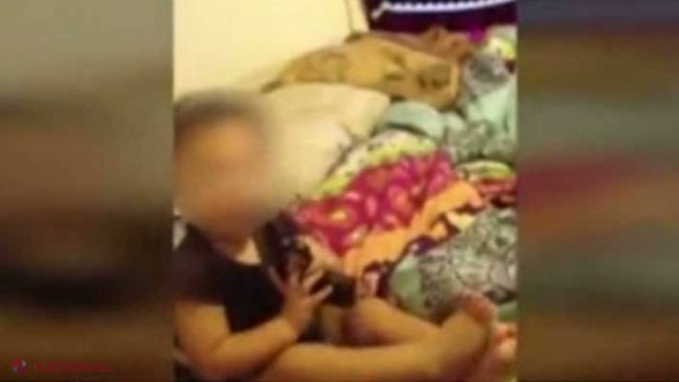 ŞOCANT: Copil de un an, filmat cu arma în gură de părinţi  