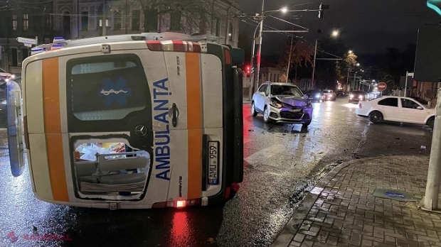 FOTO // În ambulanța lovită în plin și răsturnată în centrul Chișinăului se afla o femeie și copilul său, transportați în drum spre spital