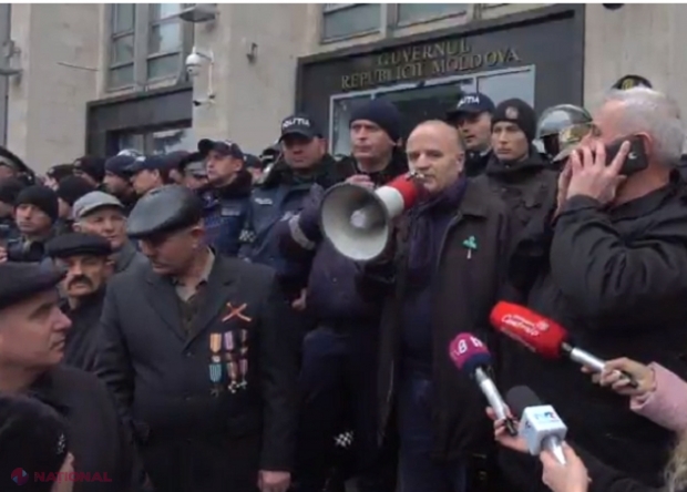 VIDEO // Autospeciala care poate dispersa mulțimea utilizând tunul de apă, parcată în spatele Guvernului: Importante forțe de ordine apără clădirea Executivului asaltată de veterani