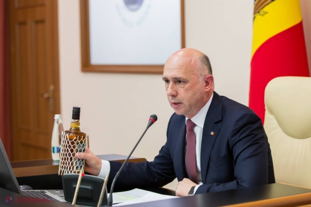 FOTO // Premierul Filip a venit cu o sticlă de WHISKEY la ședința Guvernului. Motivul care l-a determinat să facă asta